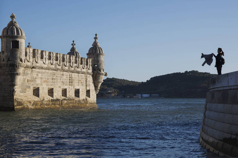 Turistas tira foto da Torre de Belém, às margens do rio Tejo, na capital Lisboa