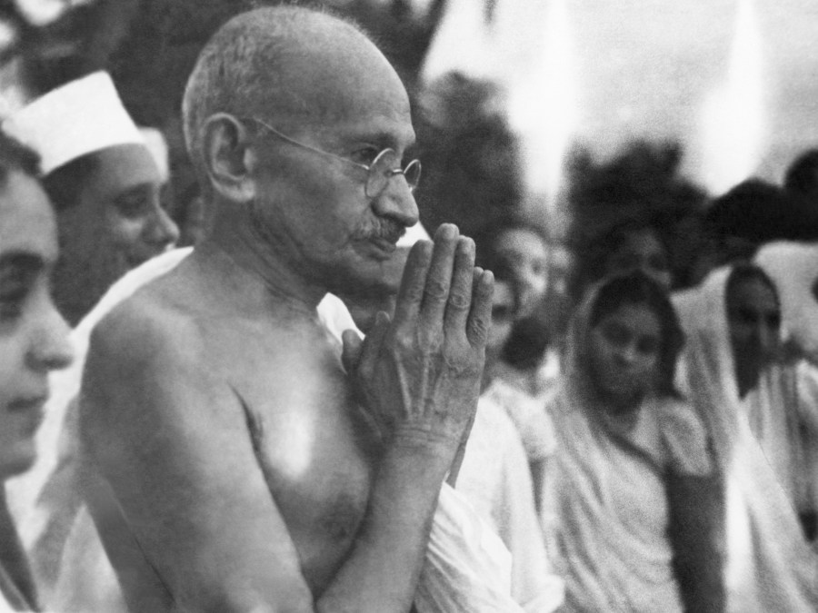 Indian statesman and activist Mohandas Karamchand Gandhi (1869 - 1948) greeting people at Juhu Beach, Mumbai, May 1944. (Photo by Dinodia Photos/Getty Images)